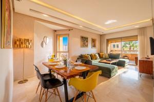a living room with a table and yellow chairs at Prestigia Family Luxury Apartments in Marrakesh