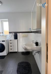a white bathroom with a sink and a toilet at BEGE APARTMENTS SmartLoft in Hof