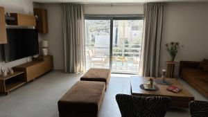 a living room with a couch and a table and a television at Naiad Villa in Vari