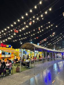 a group of people sitting at tables under lights at Lux Lettings in Noida