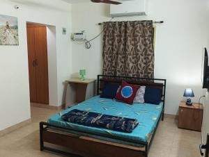 a bedroom with a bed with blue sheets and pillows at Bella Mi Casa Homestay in Chennai