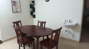 a wooden table and chairs in a bathroom with a sink at Bella Mi Casa Homestay in Chennai +10 photos