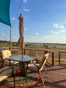 a patio with a table and chairs and an umbrella at Lakeside Sunset - Hot Tub, Pool Table, Beautiful Views!! in Canyon Lake