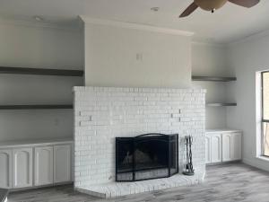 a living room with a white brick fireplace at Lakeside Sunset - Hot Tub, Pool Table, Beautiful Views!! in Canyon Lake
