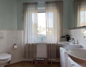 a bathroom with a toilet and a sink and a window at Haus zum Ordenswald in Neustadt an der Weinstraße