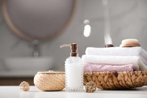 a bathroom with a basket of towels and a bottle of soap at Boho Dream Apartments in Ulcinj