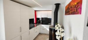 a kitchen with white cabinets and a black stove at Nebelmeer Chalet Grabs mit Panorama über das Rheintal in Grabs
