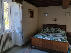 a bedroom with a bed and a window at Gite les Tulipes in Liernais