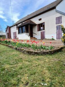 a house with flowers in front of it at Gite les Tulipes in Liernais