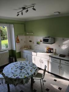 a kitchen with a table and a kitchen with green walls at Gite les Tulipes in Liernais