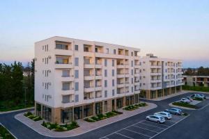 an apartment building with cars parked in a parking lot at Boho Dream Apartments in Ulcinj