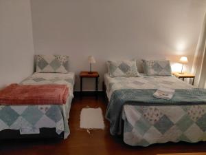 a small room with two beds and a lamp at Pouso do Rancho in São José do Barreiro