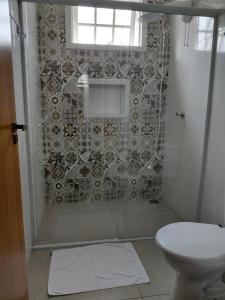 a bathroom with a shower and a toilet at Pouso do Rancho in São José do Barreiro