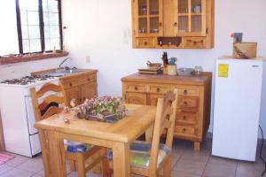 a kitchen with a wooden table and a white refrigerator at El Rincón de San Agustín Etla in San Agustín Etla