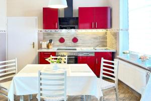 a kitchen with red cabinets and a table with chairs at Zach Family in Lübbenau