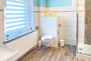 a bathroom with a toilet and a sink at Zach Family in Lübbenau +17 photos