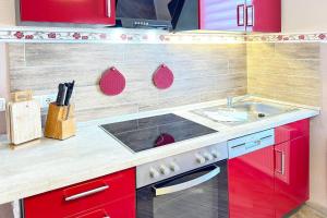 a small kitchen with red cabinets and a sink at Zach Family in Lübbenau