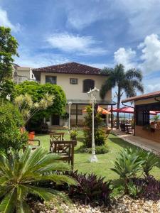 a resort with a yard with benches and trees at Restau de Marambaia in Barra de Guaratiba