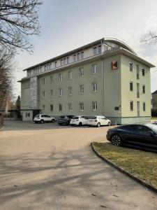 a large building with cars parked in a parking lot at Kolpinghaus Villach in Villach