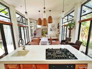 a kitchen with a stove top oven next to a living room at Casa Isla - Private Retreat in Galapagos in Puerto Baquerizo Moreno