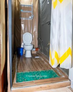 a bathroom with a toilet in a shower stall at Njukiini Forest Lodge in Embu +30 photos