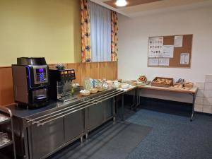 a kitchen with a counter with a microwave and a table with food at Kolpinghaus Villach in Villach