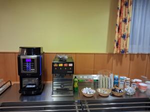 a coffee station with a coffee maker and cupcakes at Kolpinghaus Villach in Villach
