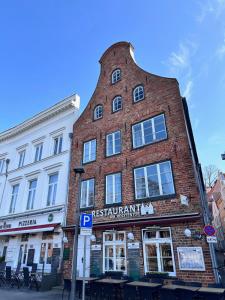 a tall red brick building with a round top at Appartementhaus Obertrave in Lübeck