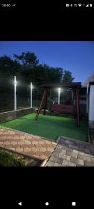 a night view of a park with a bench and lights at Casa rustică in Ludoş