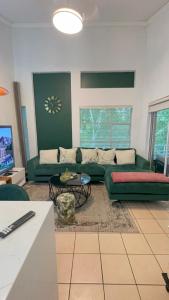 a living room with a green couch and a table at The Urban Nest in Nelspruit