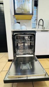 an open dishwasher in a kitchen with a counter at The Urban Nest in Nelspruit +6 photos