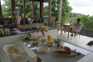 a kitchen with food and people sitting at a table at Fazenda 101 in Ilhéus