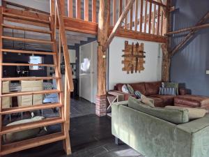 a living room with a loft bed and a couch at Hoeve 1650 in Koekange