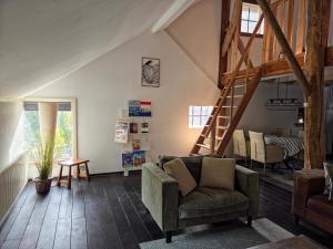 a living room with a couch and a staircase at Hoeve 1650 in Koekange