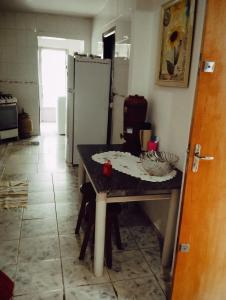 a kitchen with a table and a refrigerator at Doce lar in Maringá