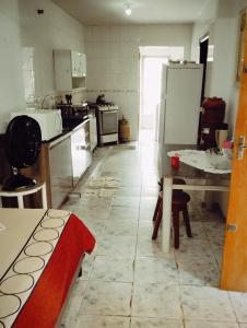 a kitchen with a table and a refrigerator at Doce lar in Maringá