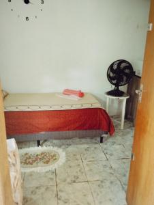 a bedroom with a bed and a table and a chair at Doce lar in Maringá