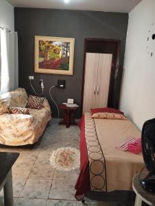 a living room with a bed and a couch at Doce lar in Maringá