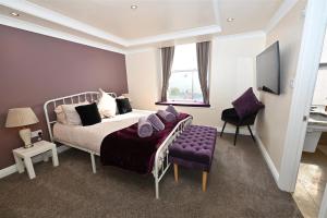 a bedroom with a bed and a purple chair at Church View Richmond - spacious, 2 bed ensuite luxury apartment in town centre in Richmond