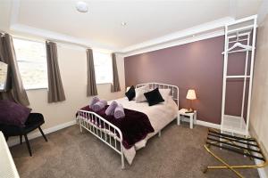 a bedroom with a bed with purple walls and a ladder at Church View Richmond - spacious, 2 bed ensuite luxury apartment in town centre in Richmond