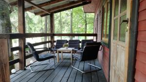 a porch with four chairs and a table on it at Oleandria -,,Domek Pokrzywa" in Biskupiec +29 photos