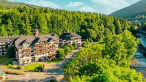 an aerial view of a resort with a river and trees at Boutique Hotel Soyka in Špindlerův Mlýn