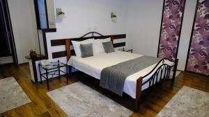 a bedroom with a large bed and two tables at NAD Inn in Sătic
