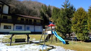 a playground in front of a house with a slide at NAD Inn in Sătic