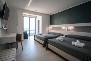 a hotel room with two beds and a desk at Hotel La Bussola in Ortona +84 photos