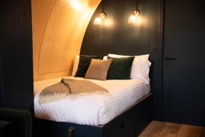 a bed in a room with two lights on the wall at Wigtown by Wigwam Holidays in Newton Stewart