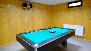 a pool table in a room with wooden walls at NAD Inn in Sătic