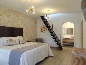 a bedroom with a large bed and a staircase at Mirador Johya Hotel in Bernal