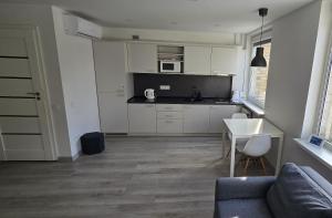 a kitchen with a couch and a table in a room at Anykščiai Center Apartment in Anykščiai