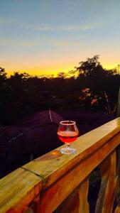 a glass of wine sitting on top of a wooden rail at Ingaru Lodge in Huamboya +43 photos